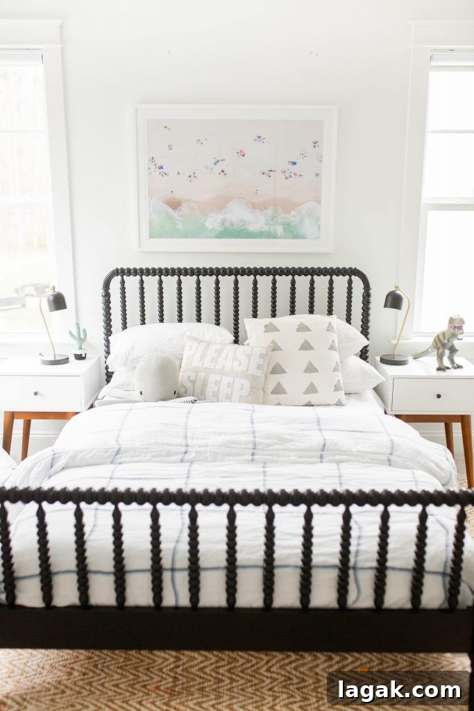 black bed and a Gray Malin print above it in a guest bedroom