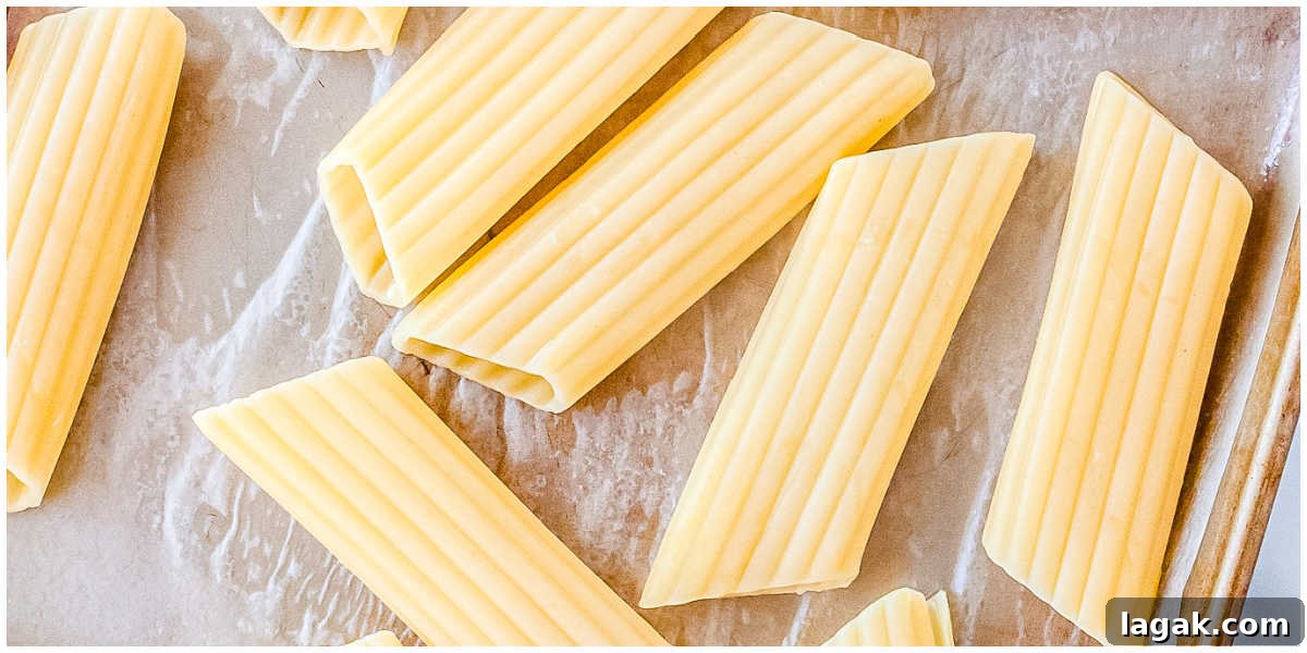 Creamy Three-Cheese Manicotti with Homemade Tomato Sauce 5 Cooked and drained manicotti pasta shells arranged on a baking sheet to cool slightly before filling.