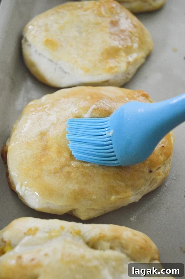 brushing butter on stuffed biscuits 