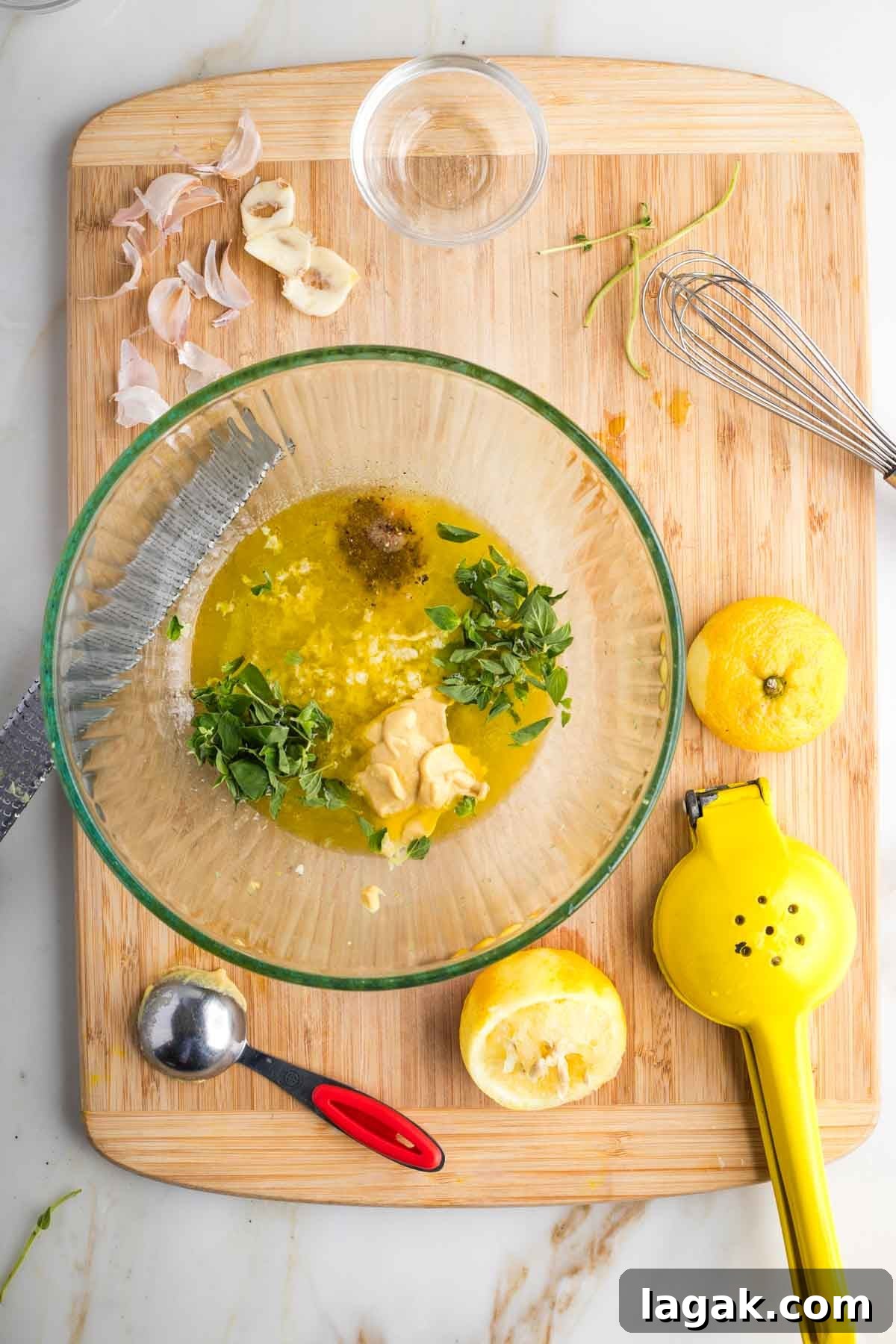 Large bowl with lemon juice, olive oil, fresh garlic, oregano and spices. 