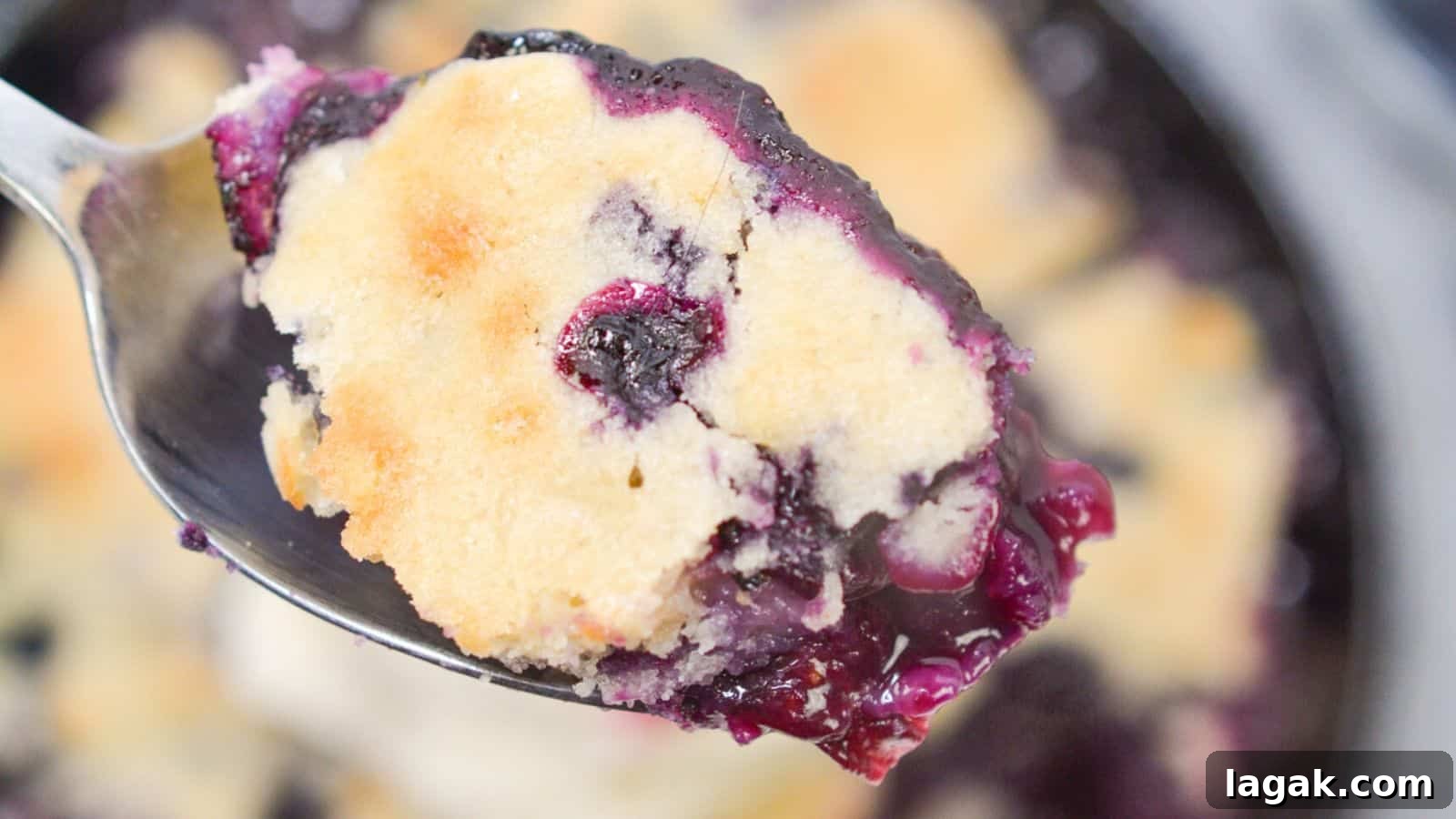 29 Party-Worthy Treats That Won’t Leave Leftovers 12 A spoon with blueberry cobbler with rest of cobbler in background.