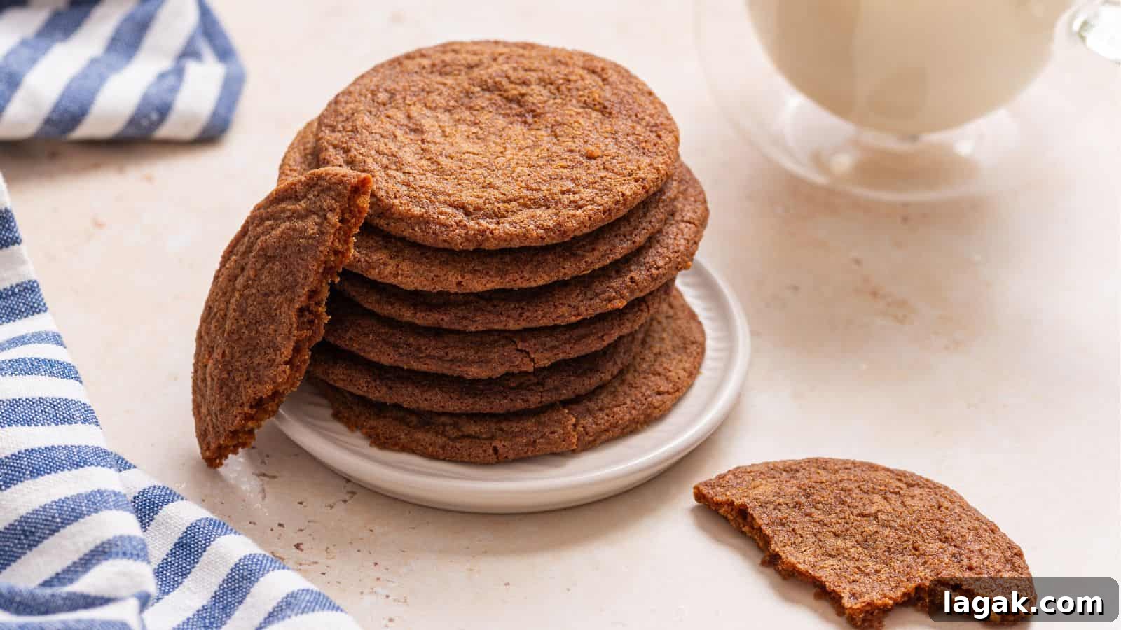 29 Party-Worthy Treats That Won’t Leave Leftovers 13 A stack of crisp brown sugar cookies on a plate with one cookie broken in half, accompanied by a glass of milk and a striped napkin.
