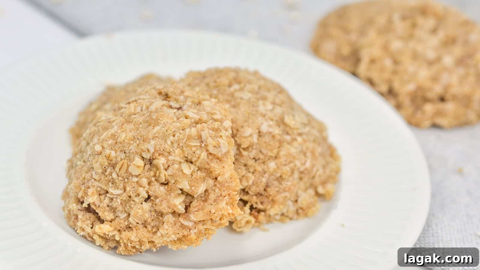 29 Party-Worthy Treats That Won’t Leave Leftovers 25 Two oatmeal cookies on a white plate, with a crumbly texture and visible oats, displayed on a light-colored tablecloth.