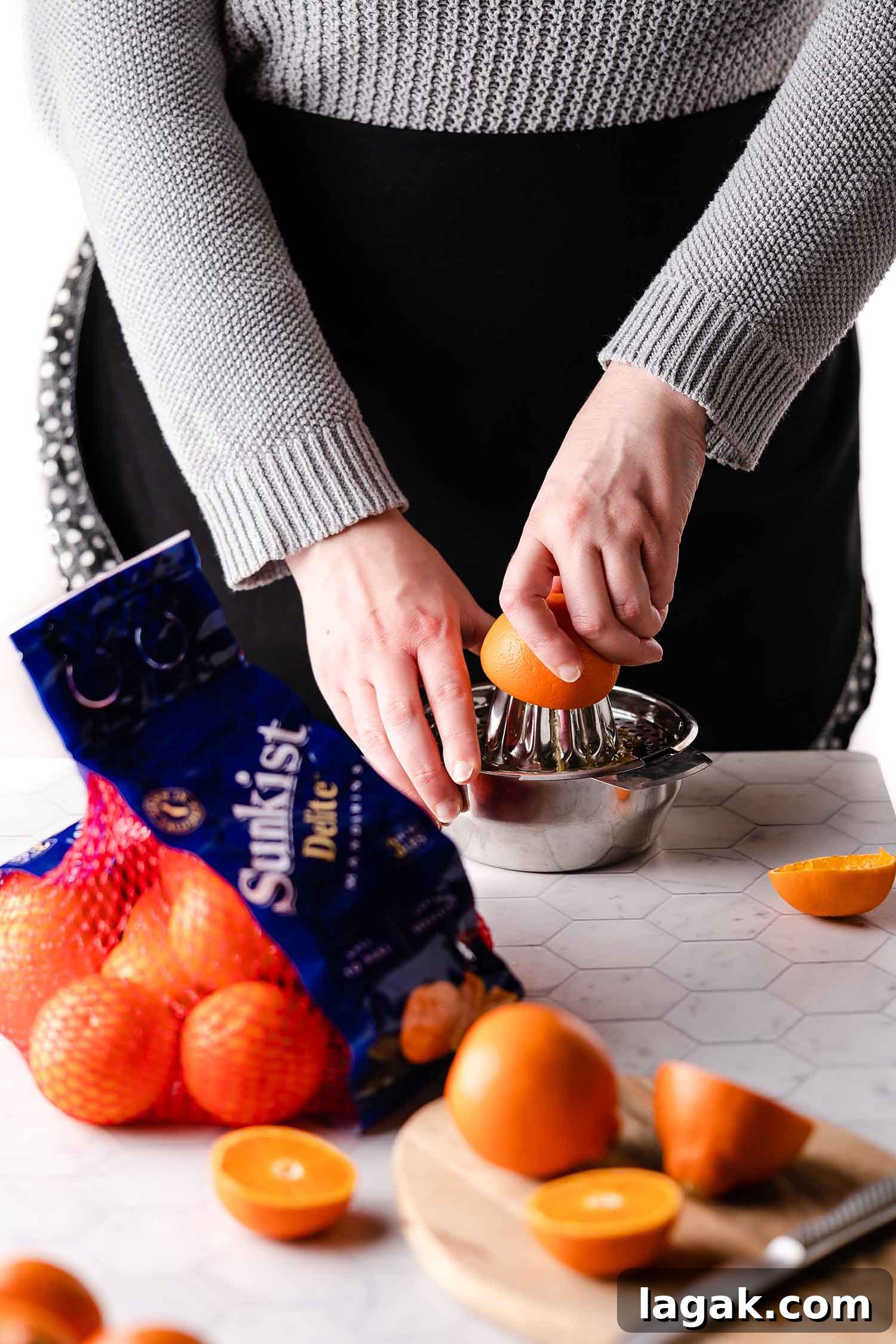 juicing oranges with oranges on cutting board