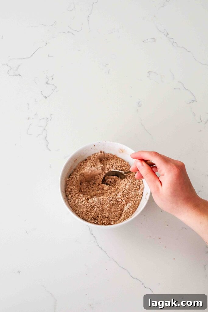 Ultimate Double Chocolate Chip Cookie Recipe for Rich, Gooey Cookies 5 A hand stirs together dry ingredients in a bowl for double chocolate chip cookies.
