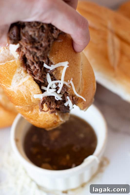 Crock-Pot French Dip Sandwich Recipe for Tender, Flavorful Beef 7 French Dip Sandwich being dipped in au jus.