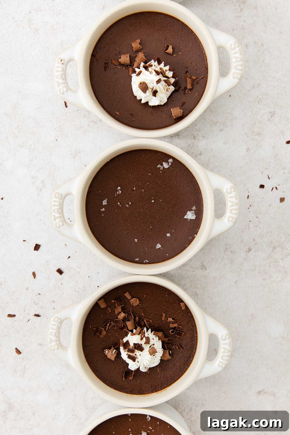 Silky Dark Chocolate Pot de Crème Recipe 7 overhead of pot de creme with some topped with whipped cream and chocolate shavings.