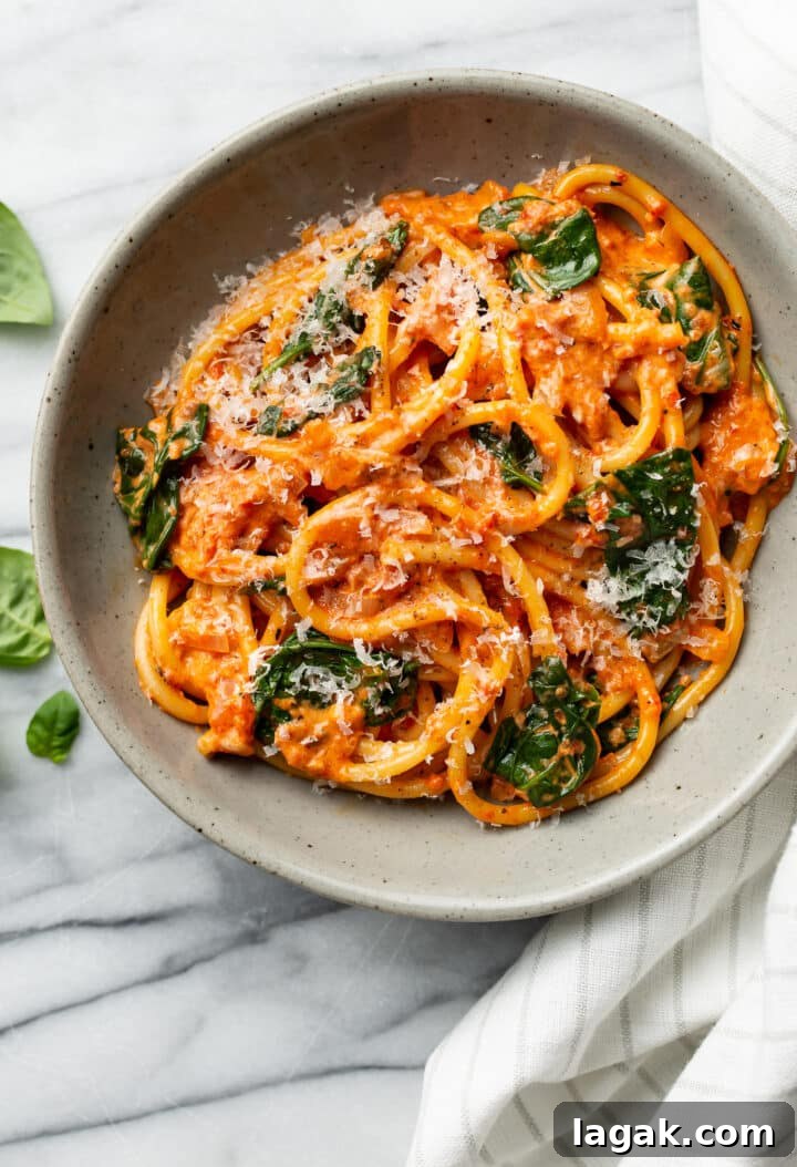 Creamy Roasted Red Pepper Pasta Recipe with Garlic and Basil 8 a bowl of roasted red pepper bucatini next to a cloth napkin