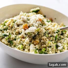 Kale Quinoa Salad with Honey, Lemon and Dijon Dressing in large white serving dish with spoon.