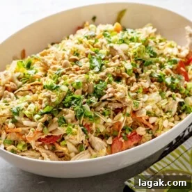 Indonesian Chicken Salad in white serving bowl on table.