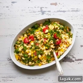 Bowl of Mayo-Free Vegan Pasta Salad on a white, wooden table.