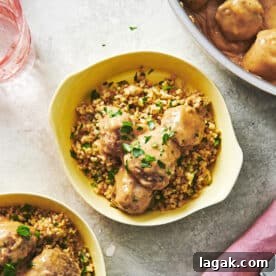 Swedish Meatballs in yellow bowls with fresh herbs on table.