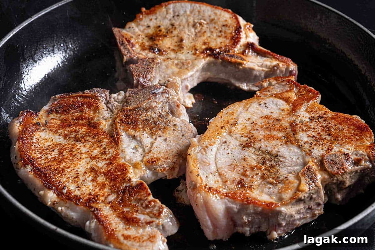 Honey Garlic Pork Chops with Sweet Glaze — Quick Weeknight Recipe 6 brown, seared pork chops sizzling in a pan