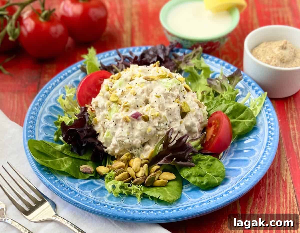 Pistachio and Poppy Seed Chicken Salad Recipe with Citrus Dressing 3 Pistachio Chicken Salad on a bed of spring greens on a blue plate.