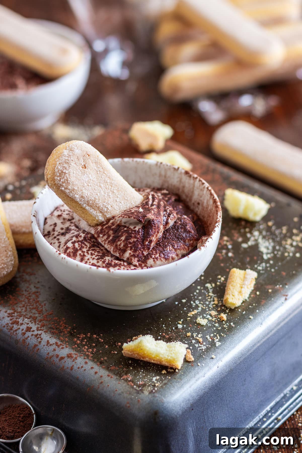Quick Tiramisu Dip — Ready in 5 Minutes 2 A small bowl of tiramisu dip with a ladyfinger biscuit, surrounded by more biscuits.
