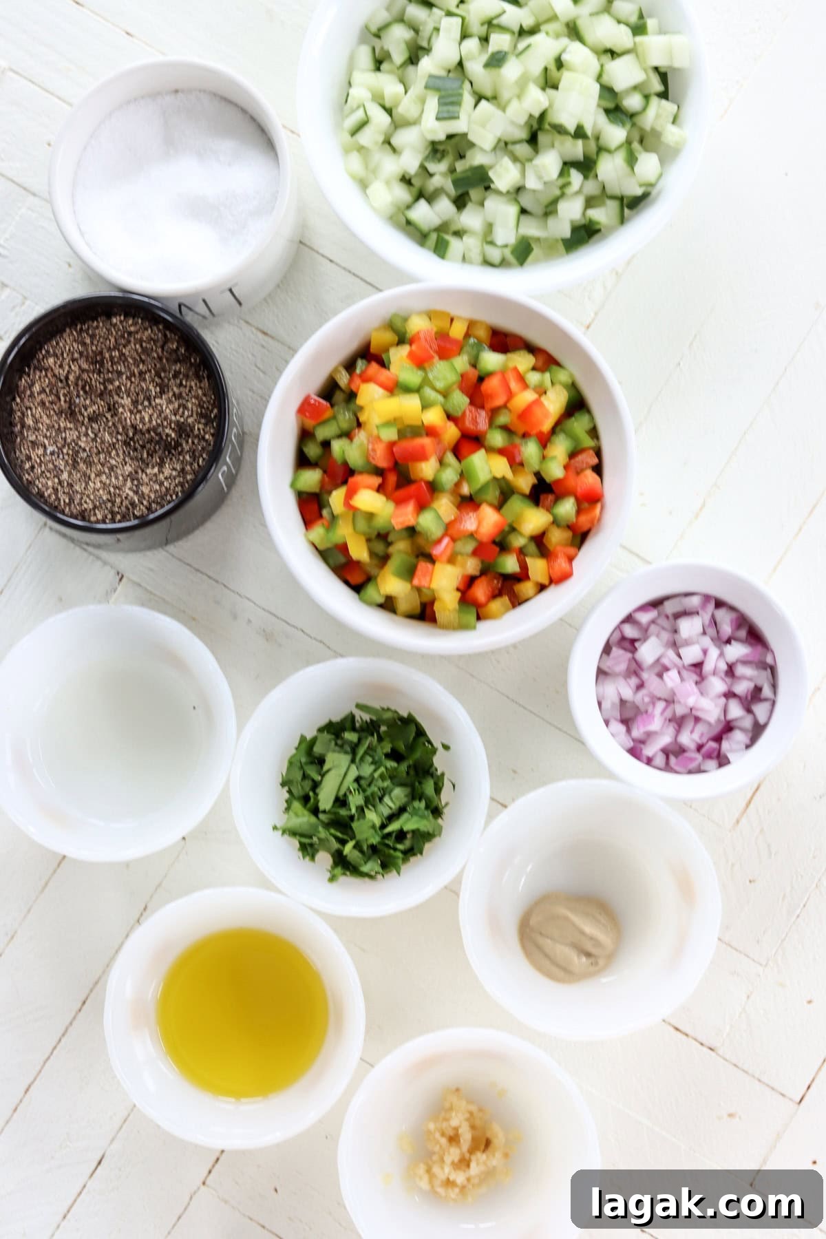 Mediterranean Cucumber and Bell Pepper Salad with Feta and Herbs 3 Ingredients needed for making cucumber bell pepper salad on a white wooded board.