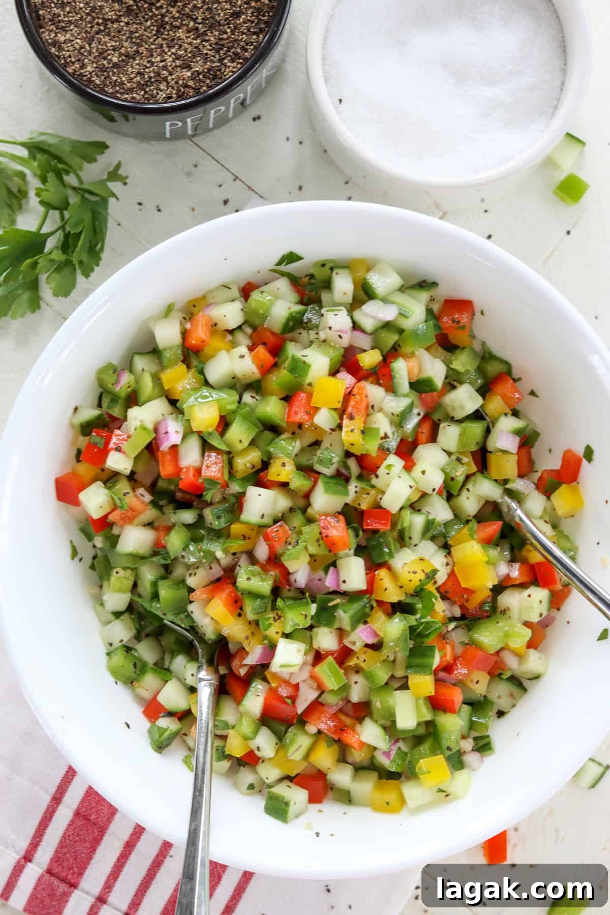Mediterranean Cucumber and Bell Pepper Salad with Feta and Herbs 6 Chopped colorful bell pepper and cucumber sald in a white bowl.