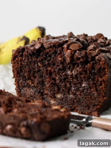 Chocolate banana bread sliced with a knife.