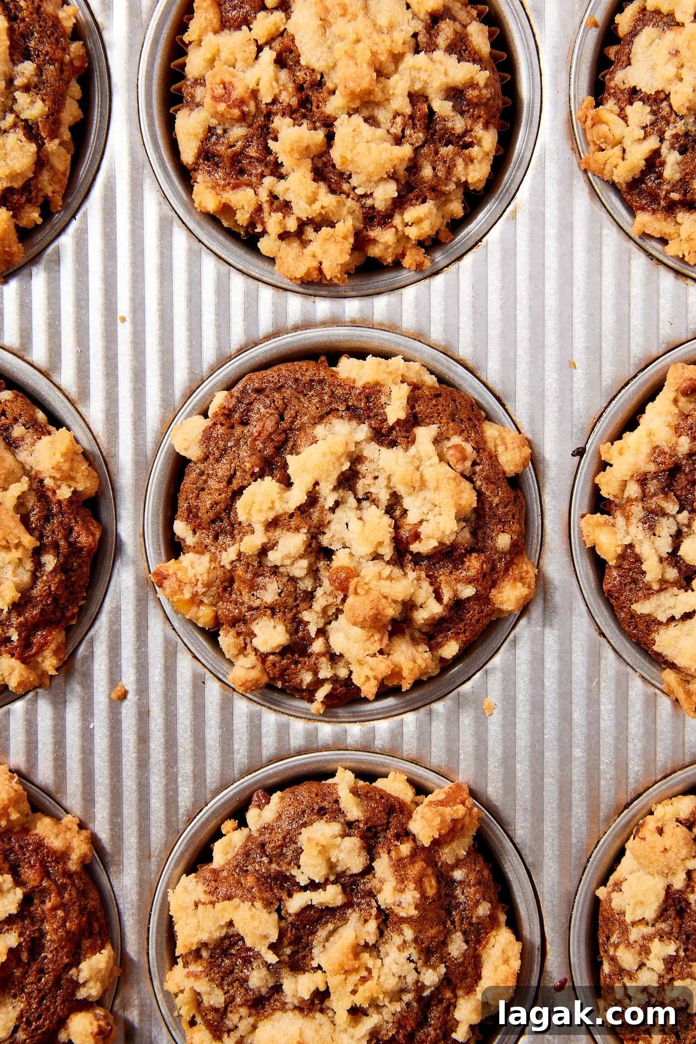 Warm Spiced Carrot Muffins with Cinnamon and Ginger 17 Metal baking pan filled with baked spiced carrot muffins with streusel topping all over.