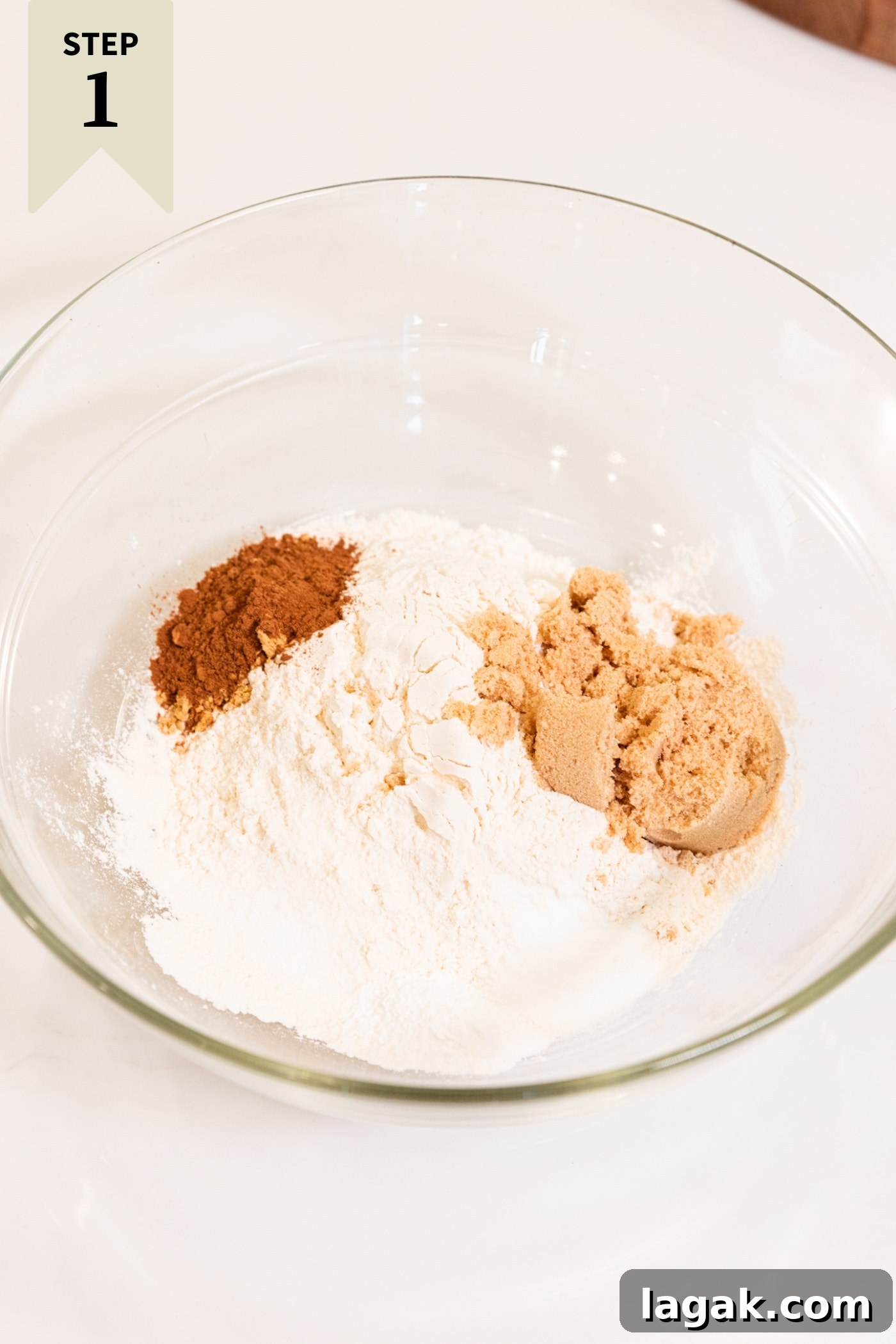 Warm Spiced Carrot Muffins with Cinnamon and Ginger 5 Glass bowl filled with flour, sugar, brown sugar, and spices before being mixed together.