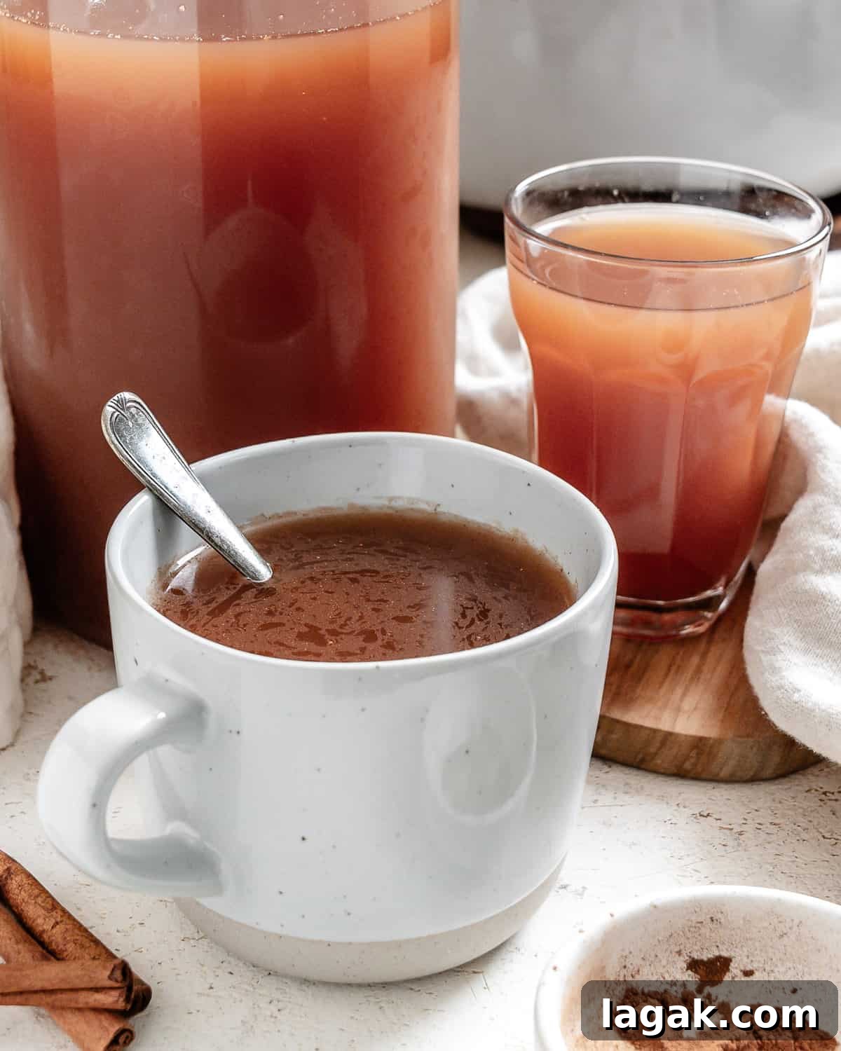 completed Mulled Apple Cider in two cups and a pitcher