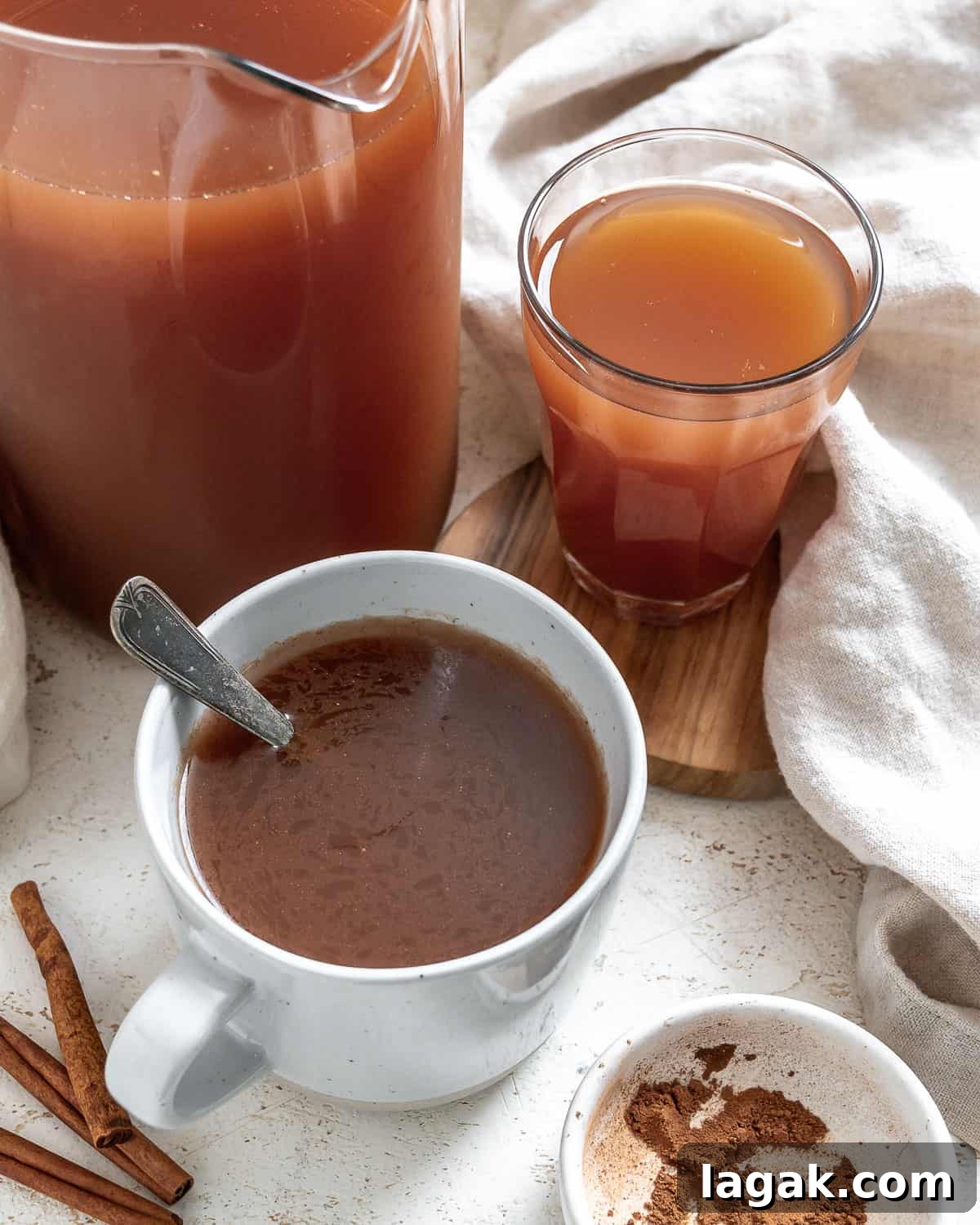 completed Mulled Apple Cider in two cups and a pitcher