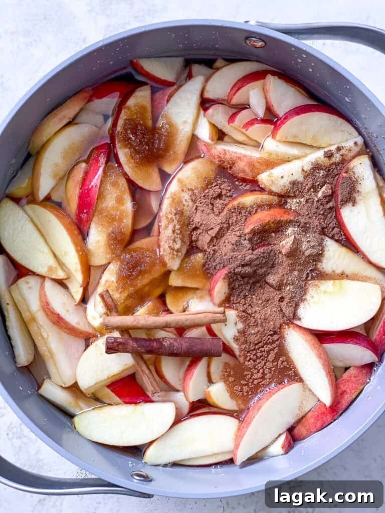 spices added to bowl of apples
