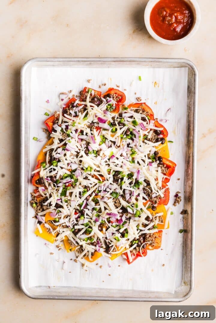 Bell Pepper Nachos with Zesty Cheese and Fresh Toppings 8 Bell peppers on a sheet pan topped with chopped jalapeno and red onion