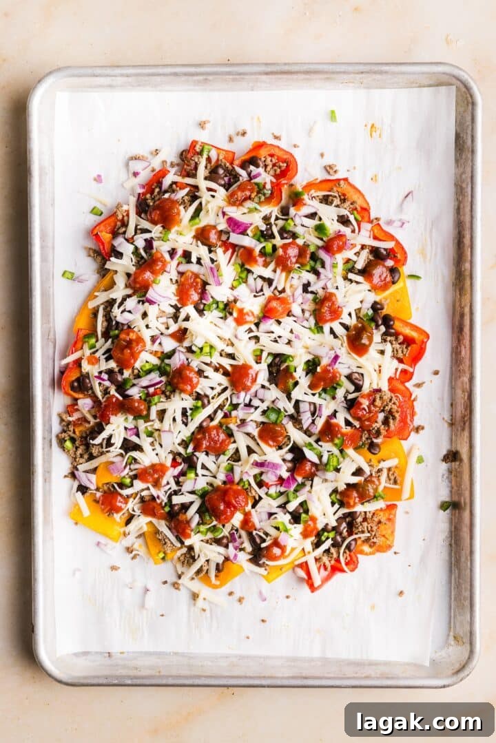 Bell Pepper Nachos with Zesty Cheese and Fresh Toppings 9 Bell peppers on a sheet pan topped with salsa and ready to go in the oven as bell pepper nachos