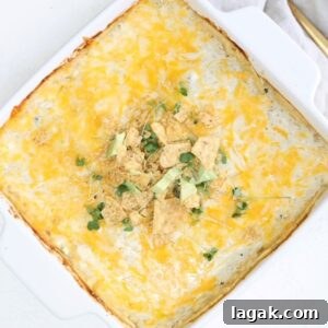 A layered enchilada bake topped in a square white baking dish.