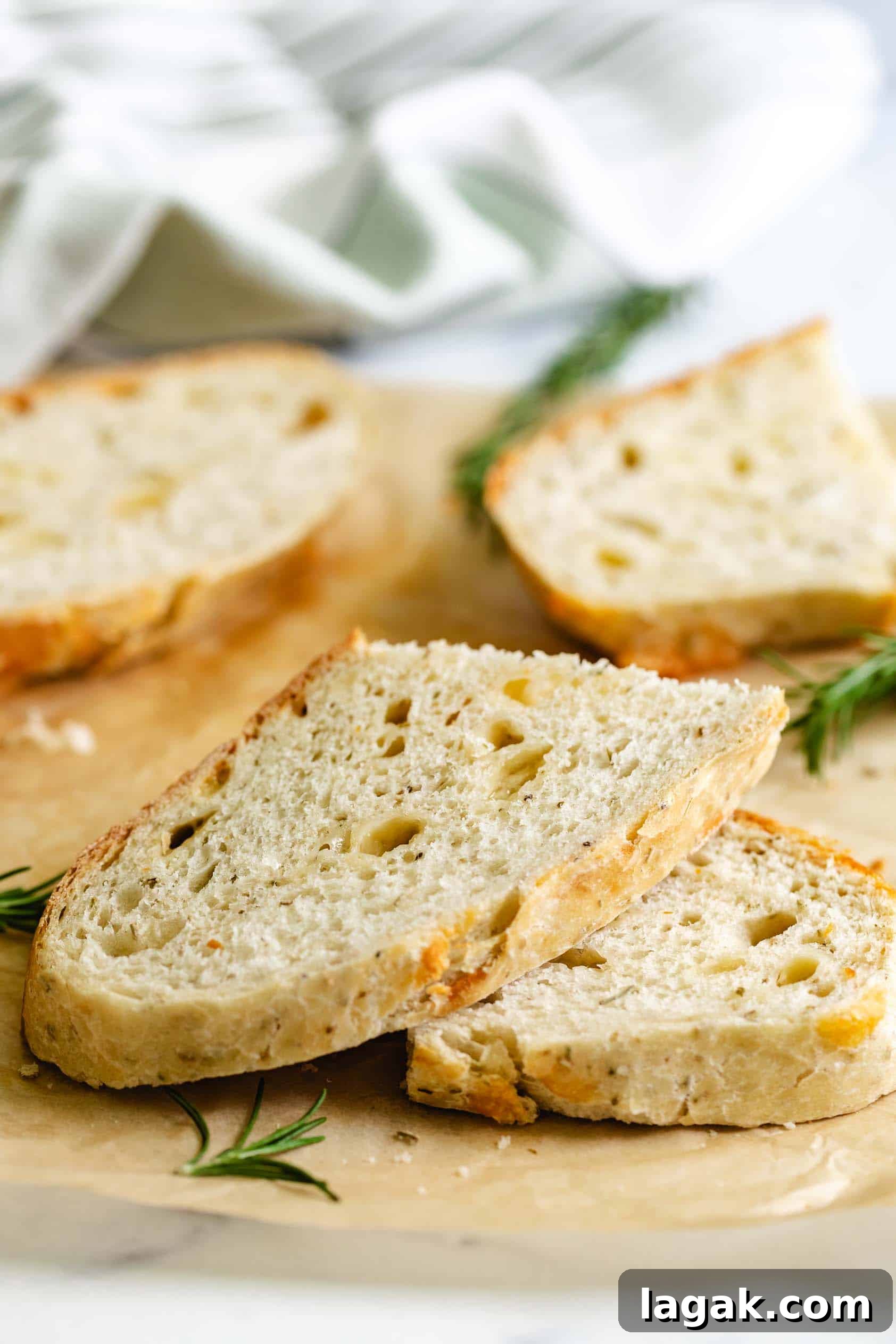 Rosemary Parmesan Loaf Recipe: Crispy Crust, Savory Interior 6 Stacks of rosemary parmesan bread next to fresh rosemary.
