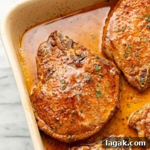Juicy Oven-Baked Pork Chops with Garlic and Herbs 7 closeup of a casserole dish with baked pork chops