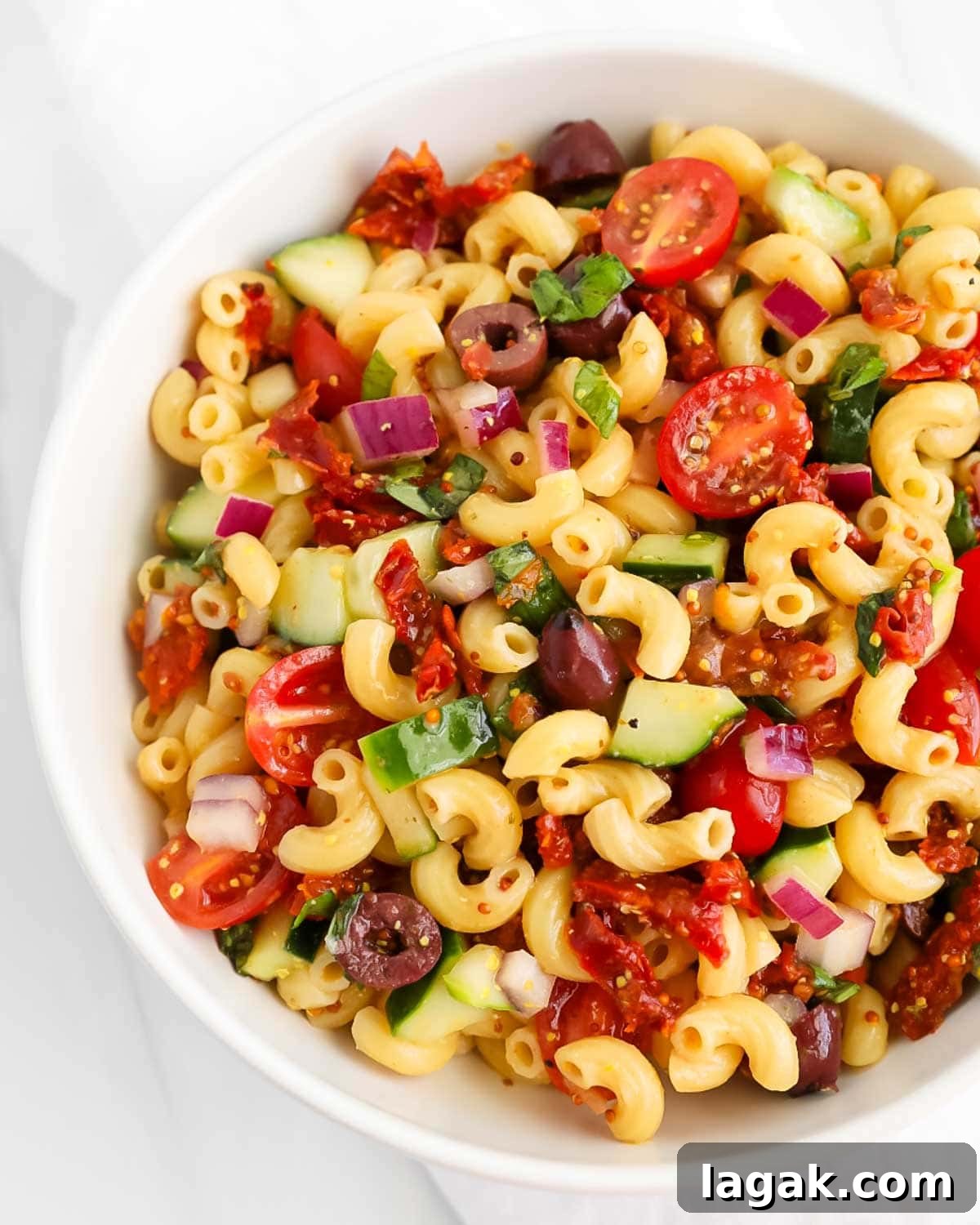 Vibrant Vegan Pasta Salad with Tangy Lemon Herb Dressing 2 A close-up picture of pasta salad in a white bowl.