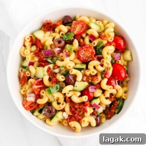 Vibrant Vegan Pasta Salad with Tangy Lemon Herb Dressing 12 A veggie-filled pasta salad in a white bowl.