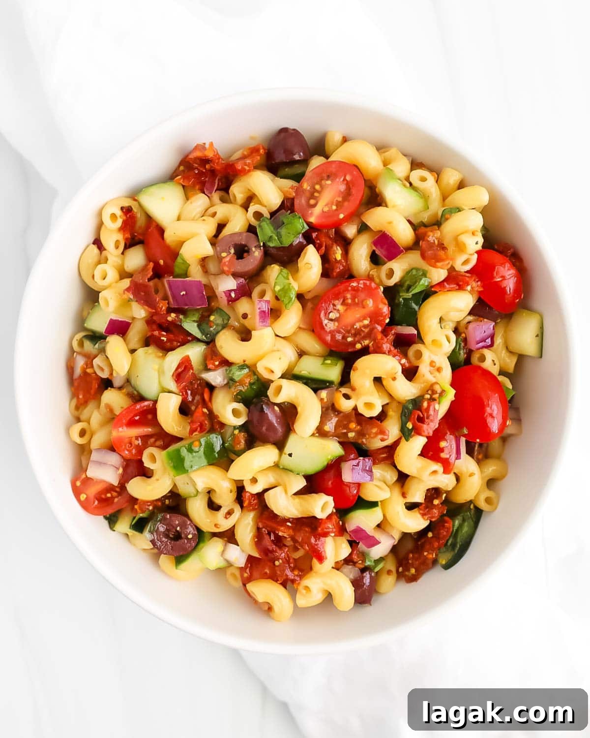 Vibrant Vegan Pasta Salad with Tangy Lemon Herb Dressing 4 An overhead image of pasta salad in a white bowl.