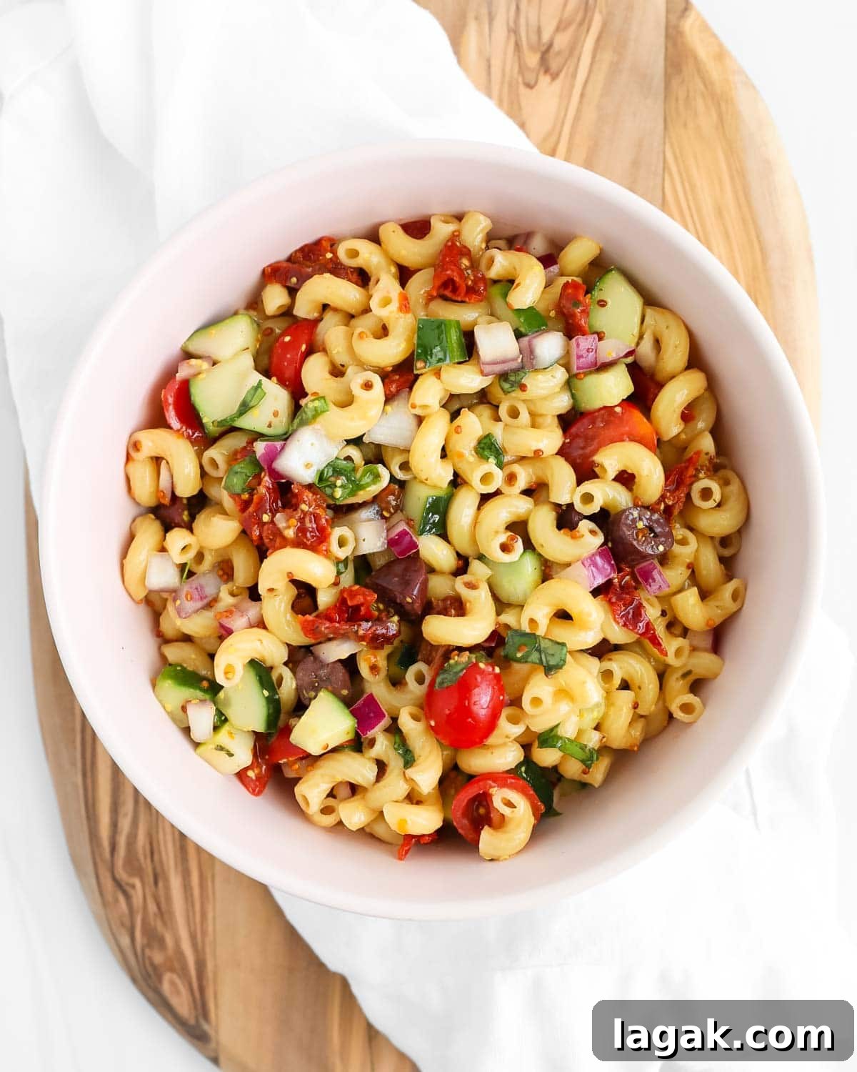 Vibrant Vegan Pasta Salad with Tangy Lemon Herb Dressing 7 A pink bowl filled with a homemade pasta salad.