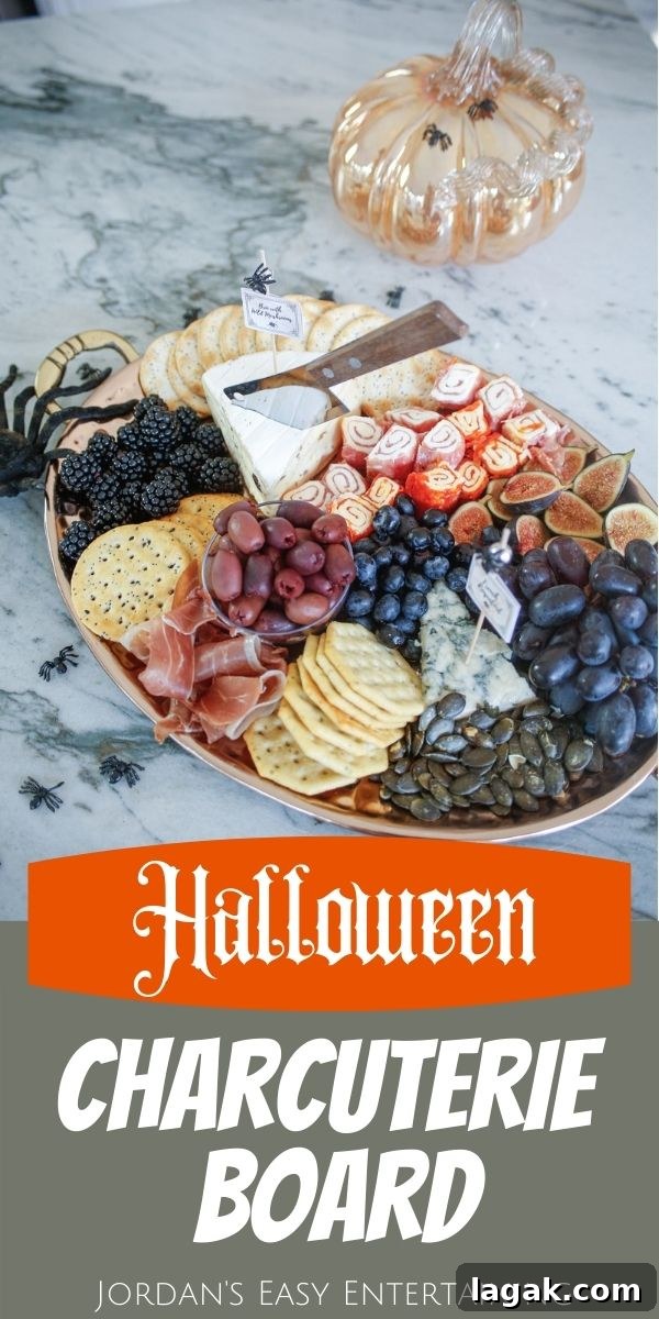A Halloween meat and cheese platter with a toy spider