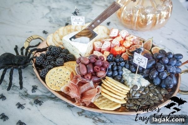 a Halloween grazing board filled with cheese, meat, fruit, crackers and styled with a spider