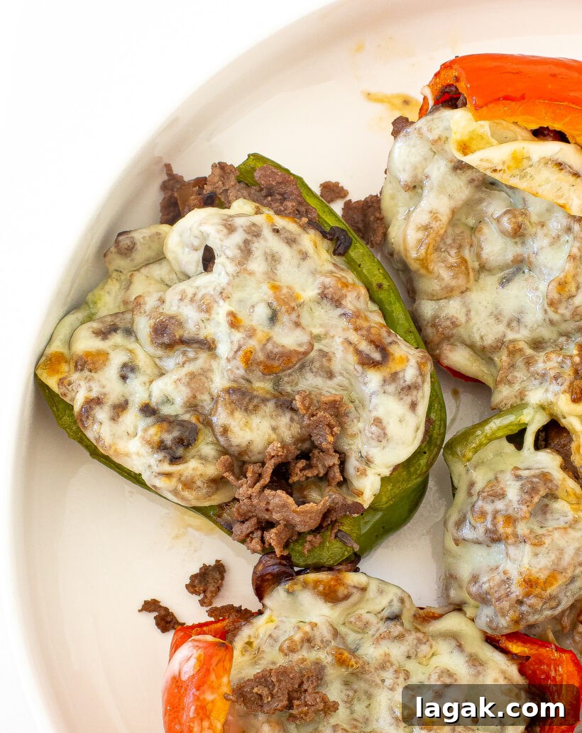 Philly Cheesesteak Stuffed Bell Peppers: Savory Low-Carb Dinner 2 Cheesesteak Stuffed Peppers on a white plate.