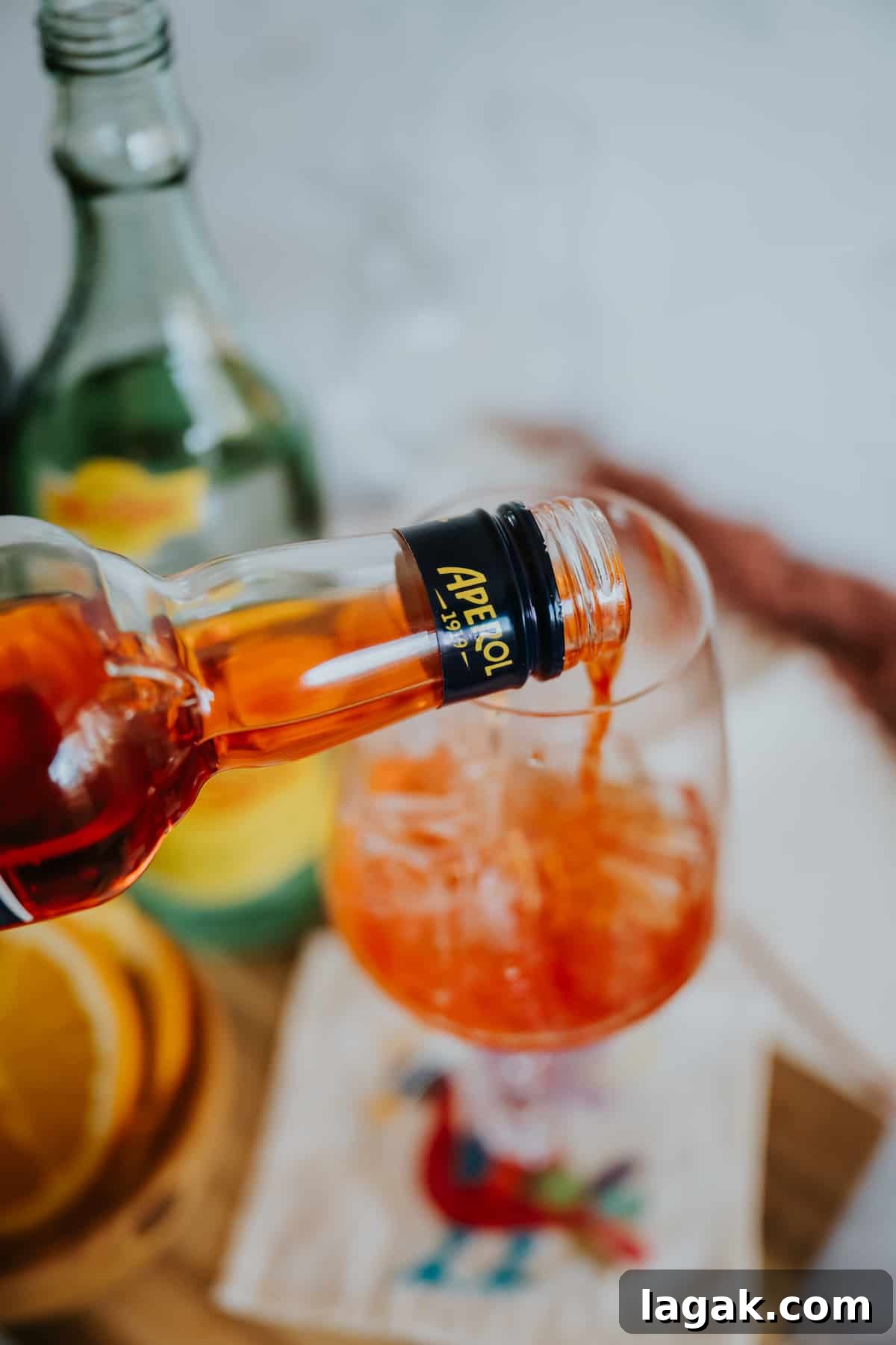 Classic Aperol Spritz Recipe: How to Make the Perfect Cocktail 4 process shot of pouring aperol into a stemmed wine glass with ice.