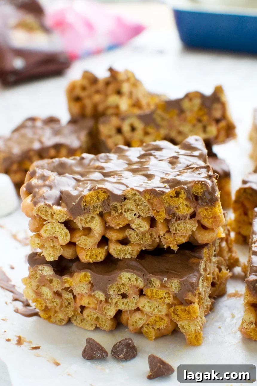 Two peanut butter cheerio bars stacked on top of each other, with others in the background