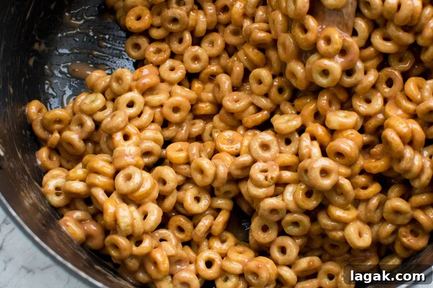 Closeup of the mixture for peanut butter cheerio bars in a pan from above