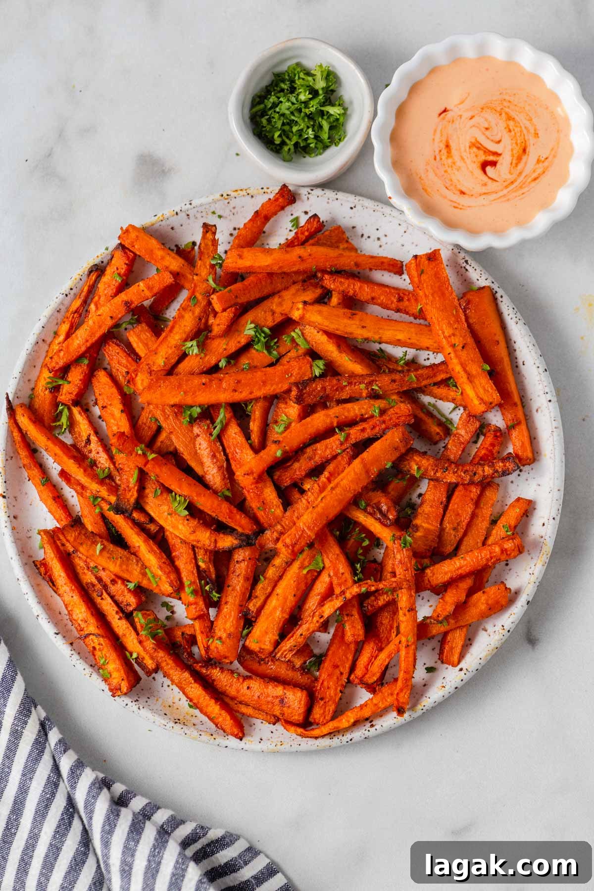 Crispy Air Fryer Carrot Fries Recipe for a Crunchy Snack 2 carrot fries on a plate with spicy mayo dip.