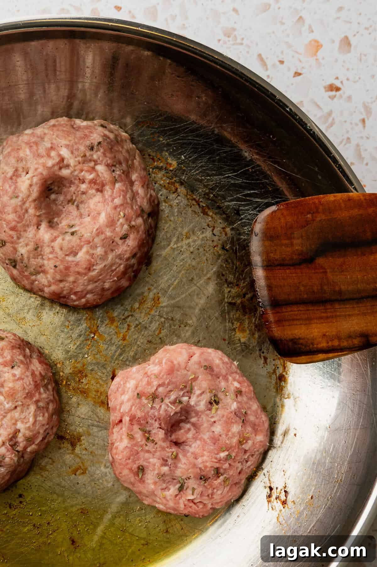 Juicy Ground Pork Burger Recipe for Flavorful Weeknight Meals 6 Uncooked ground pork burger patties in a skillet.