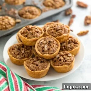 Grandma Rose’s Pecan Tassies Recipe for Perfect Bite-Sized Pies 15 A plate of mini pecan tarts with a mini muffin tin of them in the background