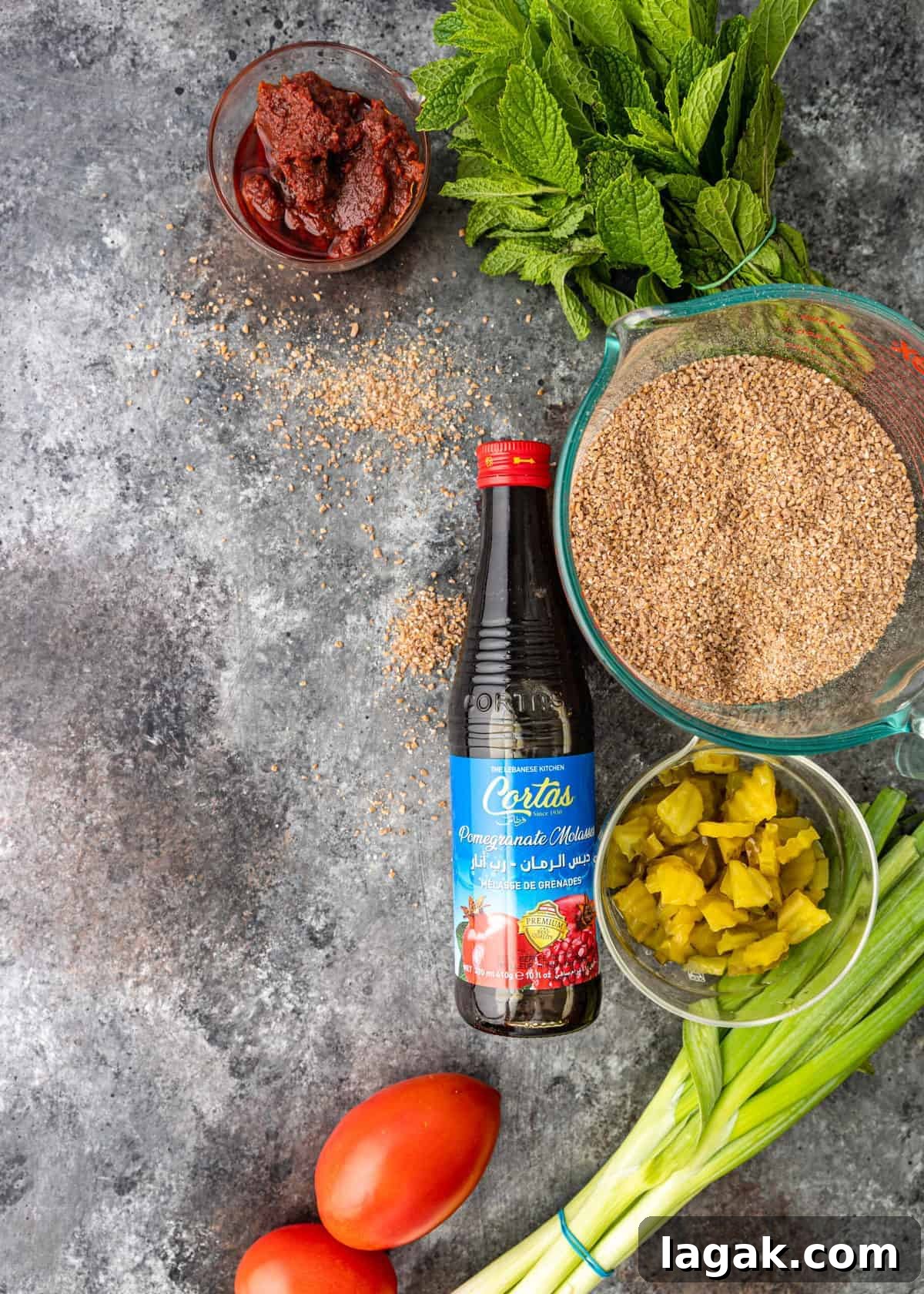 overhead: dishes of fine bulgur wheat, tomato paste and other ingredients for kisir recipe