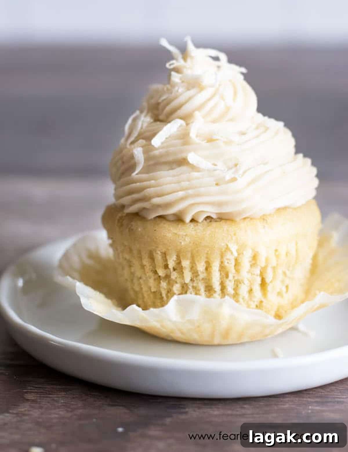A cupcake with the cupcake wrapper peeled back.