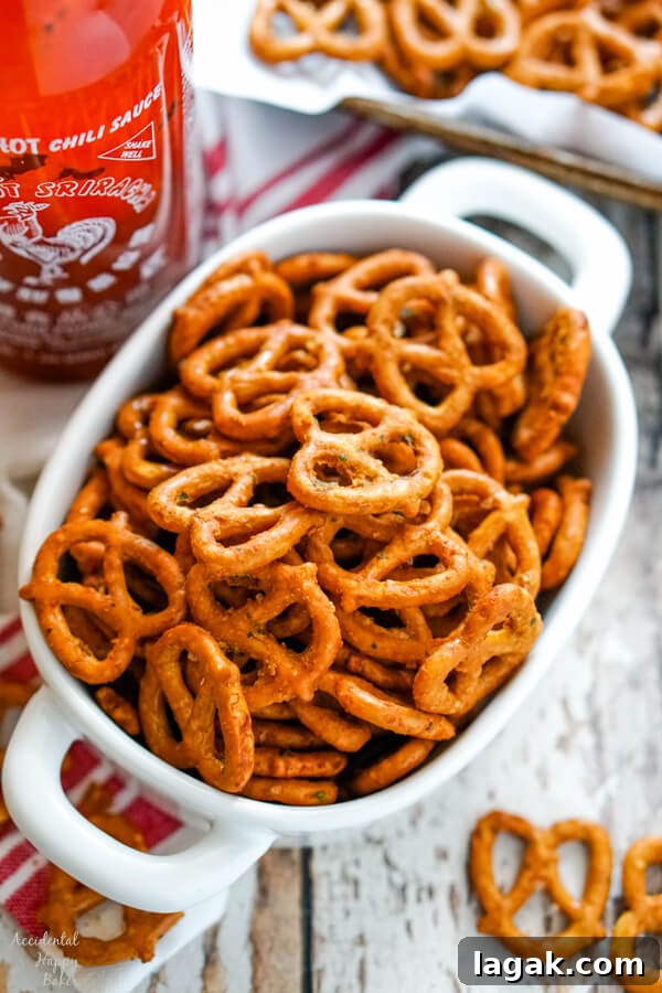 Italian Pinwheel Appetizers: Savory Tortilla Roll-Ups Recipe 8 A white bowl full of spicy ranch pretzels next to a bottle of sriracha sauce.
