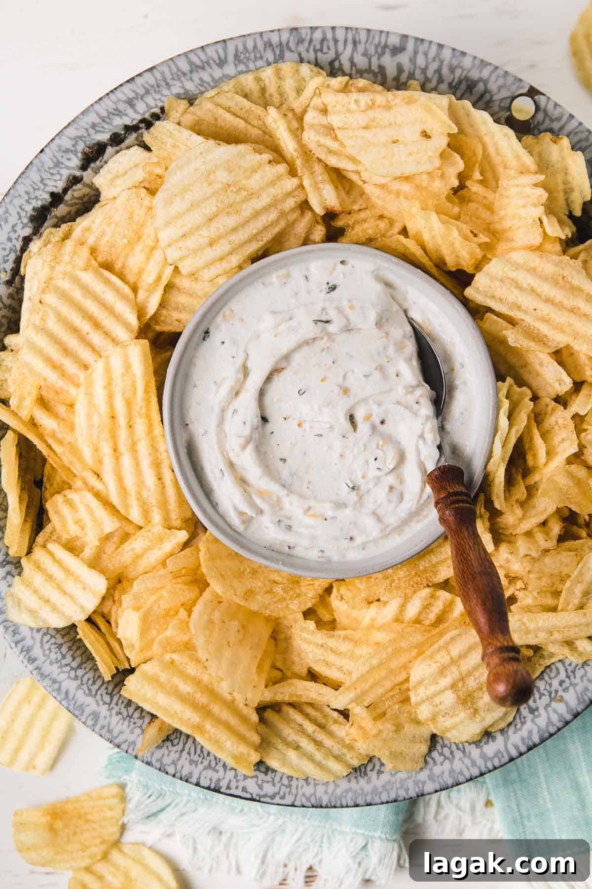 Gluten-Free French Onion Dip for Chips and Veggies 2 Gluten-free French onion chip dip in old enamelware bowl surrounded by wavy potato chips.