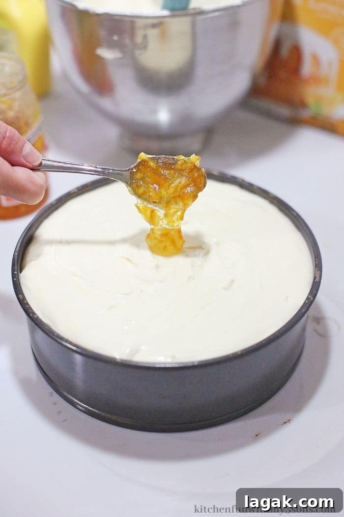 No-Bake Orange Cream Cheesecake Recipe for Zesty Summer Desserts 5 Adding the marmalade on top of the batter.
